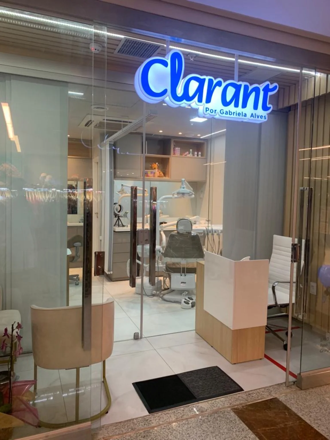 Entrada da Clarant com recepção e consultório visíveis através da fachada de vidro